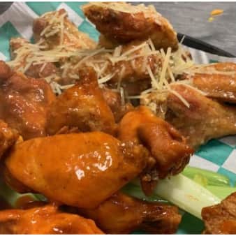Bone-in wings tossed in sauce and topped with parmesan