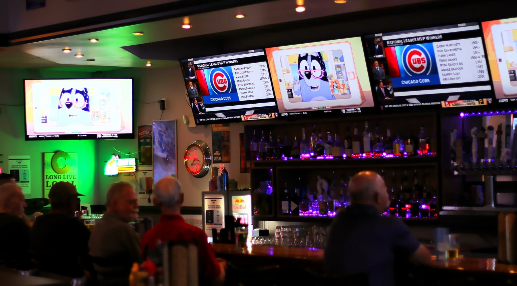 Regulars at The 303 Sports Grill in Lone Tree under a wall of TVs